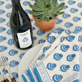 close up of Pomegranate blue and white table cloth and napkins with bottle of wine on a table
